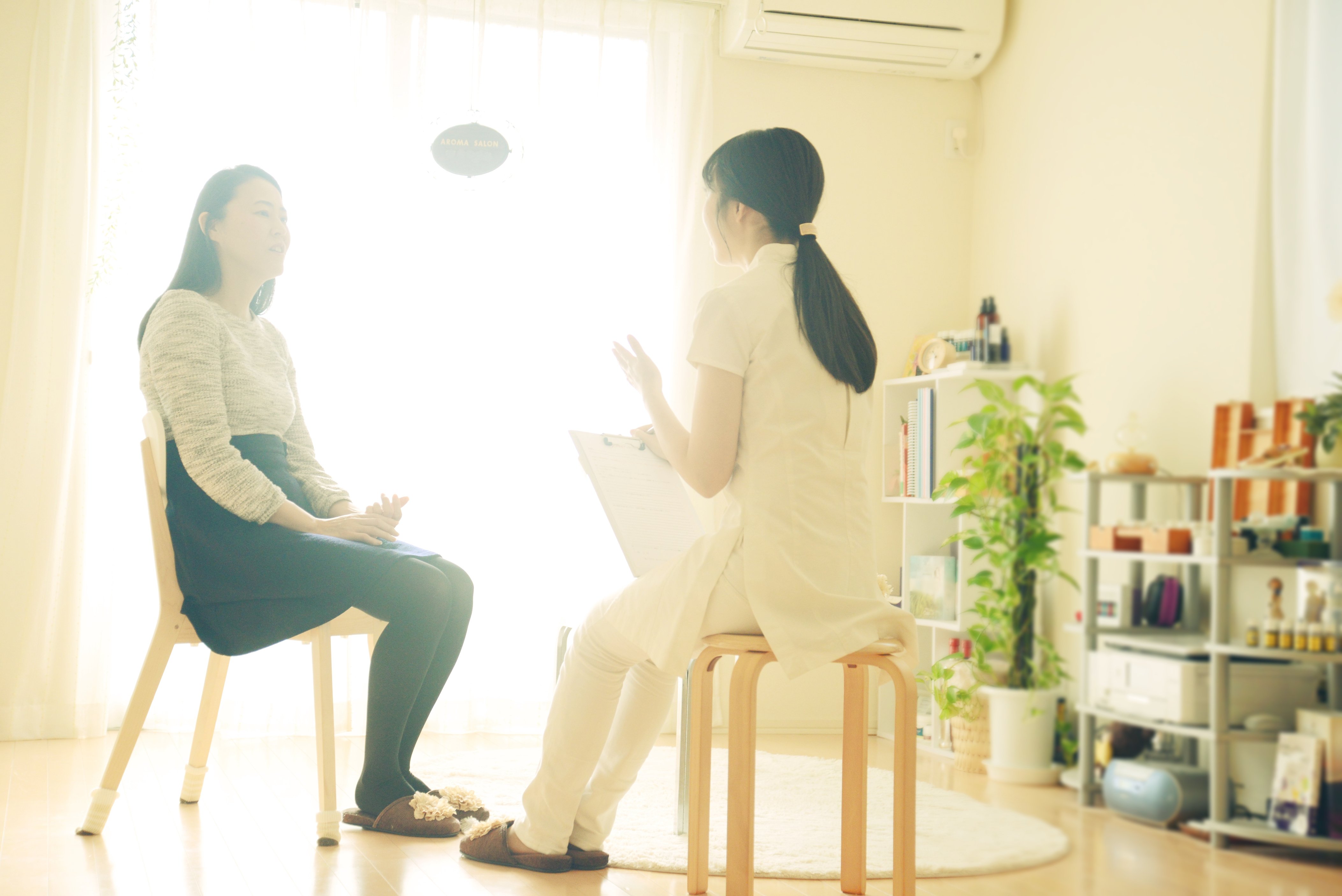 Young woman's aromatherapist counseling patient